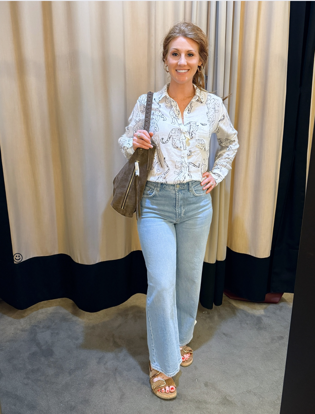 woman with red hair wearing a button shirt with leopards and embroidered light wash jeans